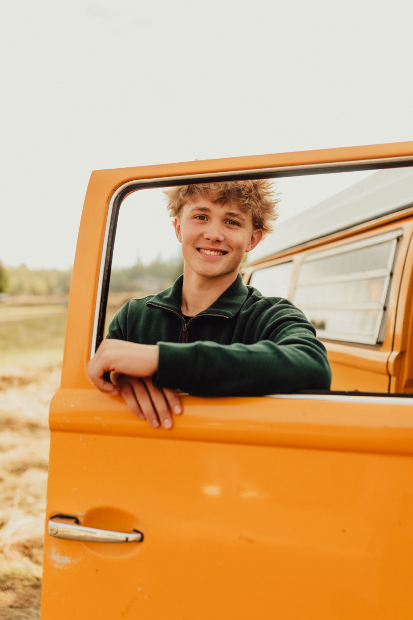 Wyatt smiling beside an orange vehicle